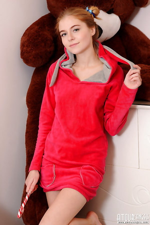 Redhead teen Chloe aka Anya Mozok in red hoodie licking lollipop on bed