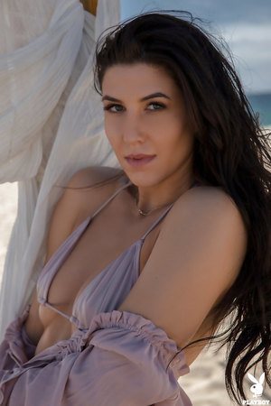 Sultry brunette Carmen Nikole poses naked on a sandy beach