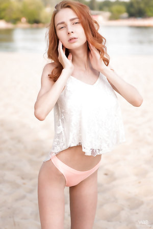 Hot skinny redhead Helga Grey undressing by the lake to show big tits