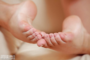 Brunette teen Rogned strips naked in close up while reading a book on a couch