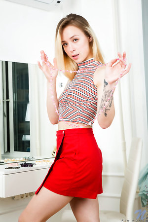 Inked petite blondie Ria Koks spreads her pussy lips to reveal a tight vulva